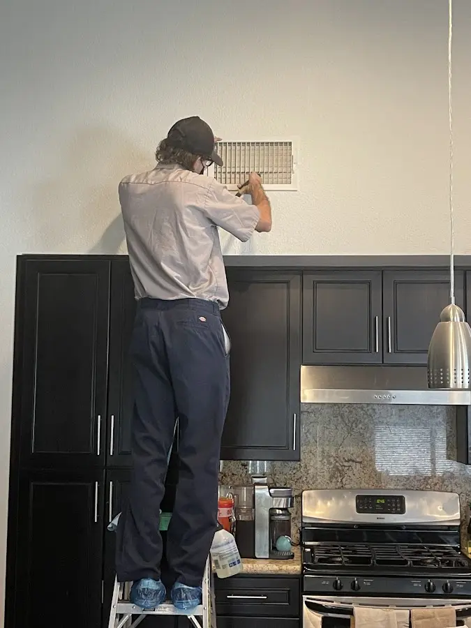 Technician inspecting an air vent during HVAC service in Stroudsburg